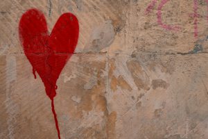 Red heart sprayed on heart wall, symbolising love and heartbreak