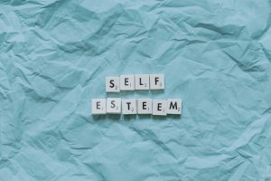 creased baby blue fabric with the word 'Self-esteem' representing one of the counselling issues I help clients with